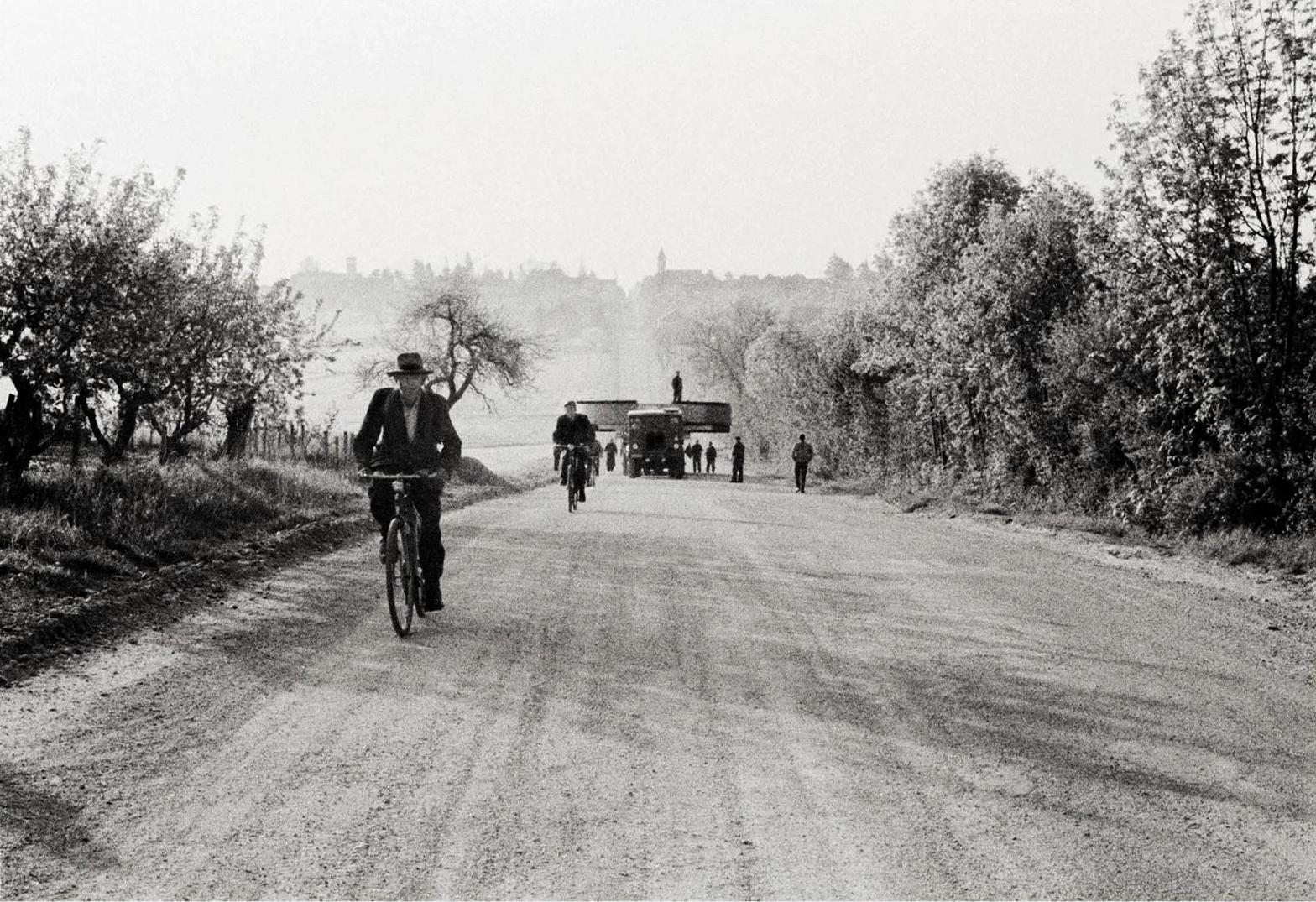 Des vélos et un camion avec un aimant géant circulant sur une route de campagne